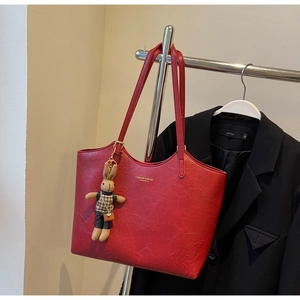 Détail du grand sac cabas rouge vintage avec texture grainée et charm lapin mignon