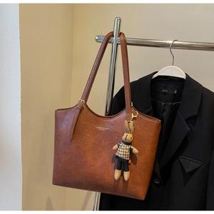 Détail du sac cabas vintage marron avec lettrage tendance et breloque lapin mignonne
