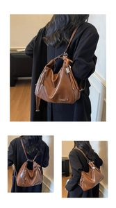 Détail du sac en cuir marron rétro avec pompons et fermeture éclair argentée de luxe