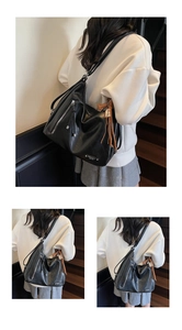 Détail du sac cabas en cuir noir avec fermeture éclair argentée et pompon marron