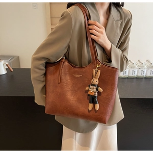 Détail du sac fourre-tout vintage marron avec texte et charmant lapin en peluche