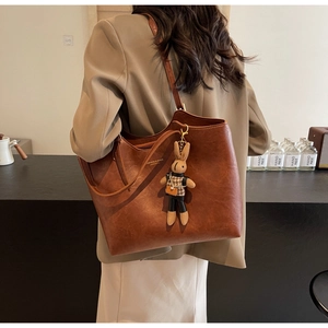 Détail du sac cabas marron avec texte 'FASHION & BAGS' et un pendentif lapin mignon