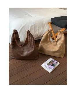 Close-up of luxury woven tote bags in brown and beige colors with intricate leather craft
