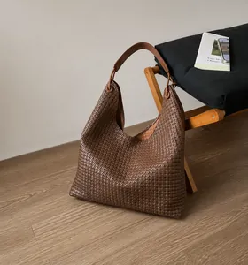Detailed view of dark brown woven texture on an oversized faux leather hobo tote bag