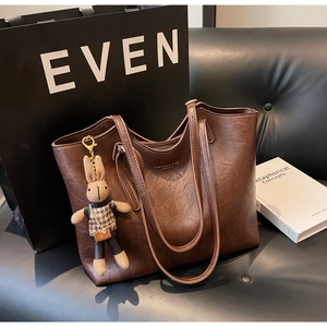Gros plan sur un grand sac cabas vintage marron avec charm lapin et texte de mode