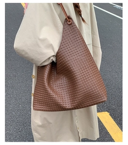 Brown woven leather tote bag with fine cross-texture and sleek shoulder strap detail