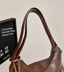 Detail of comfortable brown faux leather shoulder straps with metallic silver rings