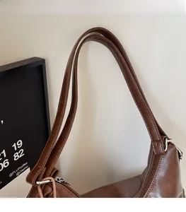 Detail of comfortable brown faux leather shoulder straps with metallic silver rings