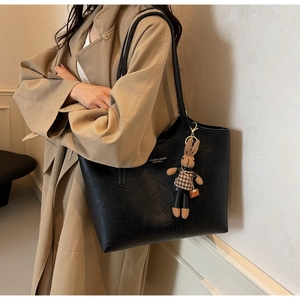 Détail du sac cabas en similicuir noir avec imprimé mode et charm de lapin peluche