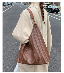 Detailed view of brown woven texture hobo bag with matching leather shoulder strap