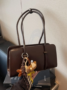 Deep brown glossy leather tote bag with stylish creative charms for vintage commuting