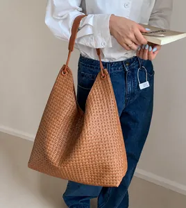 Close-up of woven brown leather tote bag detail with minimalist commuter style