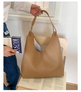 Detail of woven texture on camel hobo tote bag with metal ring handle attachment
