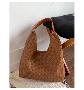 Detailed view of brown woven hobo tote bag with intricate texture and shoulder strap