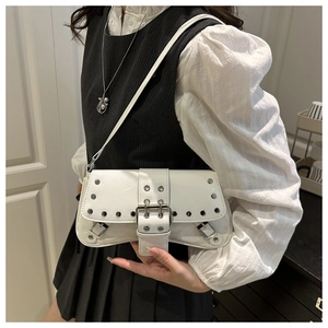 Détail de sac à bandoulière en cuir verni blanc avec rivets punk et boucle décorative