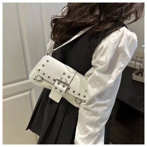 Detail of white patent leather shoulder bag with silver studs and a metallic buckle strap
