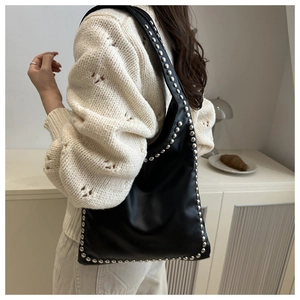 Close-up of black PU leather hobo bag with silver rivet studs on shoulder strap