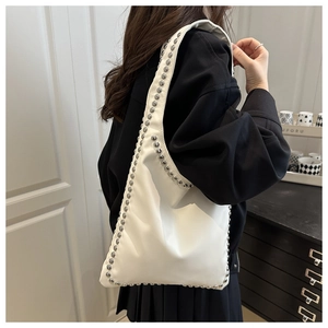 Detail of white leather shoulder bag with silver studs on Asian model showing real size