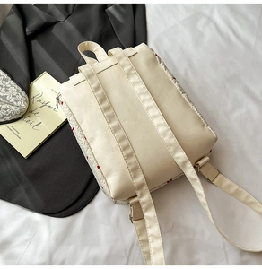 Detail of cream faux leather backpack with adjustable straps on a lifestyle background
