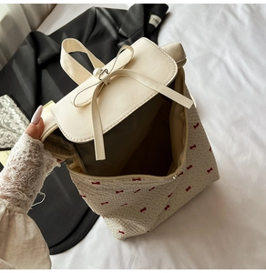 Internal view of a cream canvas backpack with red bow prints and spacious storage