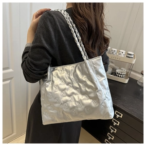 Silver tote bag with 3D bear quilted pattern and thick braided strap shown on model