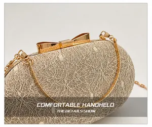 Detail of champagne gold evening clutch with lace embroidery and golden bow clasp