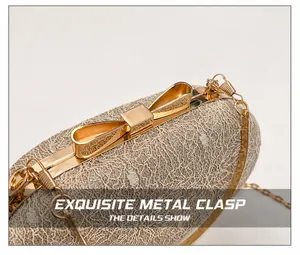 Close-up of golden bow-shaped metal clasp and lace mesh texture on evening clutch bag