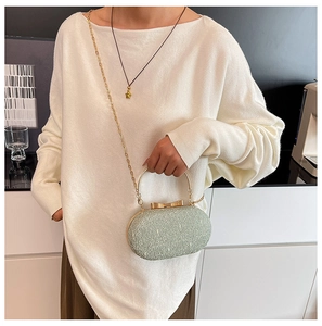 Pochette de soirée en dentelle vert menthe avec anneau doré porté par un mannequin