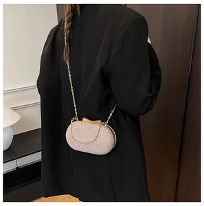 Détail du sac de soirée pailleté champagne avec fermoir nœud métallique et chaînette