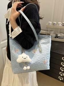 Light blue quilted tote bag with rainbow butterfly embroidery and white cloud pendant