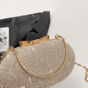 Détail du sac de soirée en dentelle champagne avec fermoir nœud et chaîne dorée