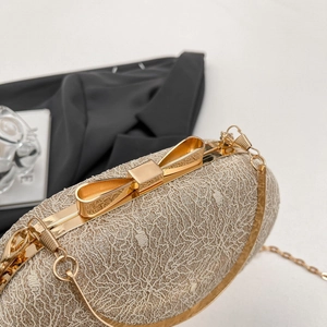Détail de la pochette de soirée champagne avec dentelle et fermoir nœud doré