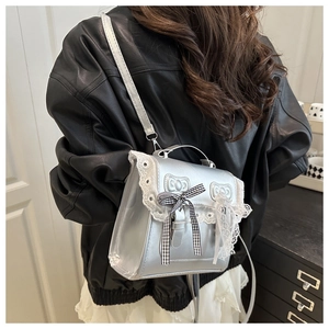 Detail of silver metallic bag with white lace trim and black gingham bow accents