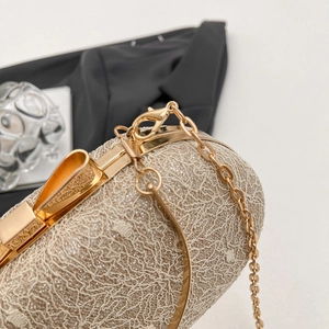 Détail d'une pochette de soirée champagne doré avec maille dentelle et fermoir nœud