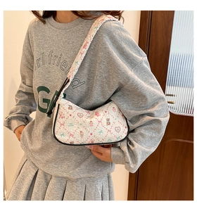 Detail of white moon bag featuring cute cartoon bear prints and black piped edges