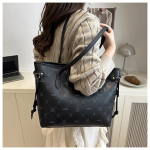 Detail view of black lychee pattern leather tote with animal print and thin shoulder strap