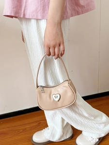 Elegant beige handbag with heart detail worn with a stylish autumn casual outfit