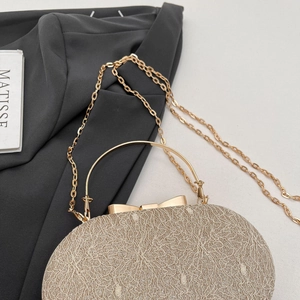 Détail du sac de soirée champagne doré avec texture melon et fermoir à nœud élégant