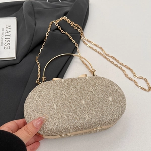 Détail d'une pochette de soirée en dentelle champagne avec poignée en métal doré