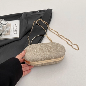 Détail d'une pochette de soirée en dentelle champagne avec une poignée dorée élégante