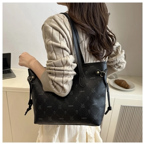 Detail of black tote bag with LNBOE logo and rabbit print shown on model's shoulder