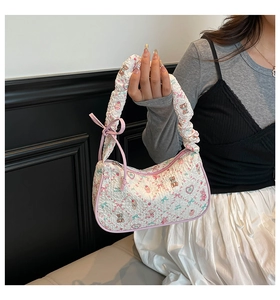 Detail of white quilted handbag with pink cartoon bear prints and bow ribbon handle