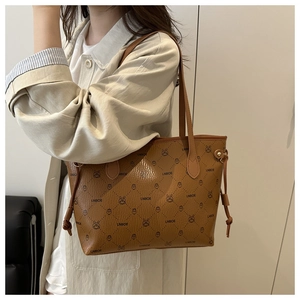 Détails d'un sac cabas marron avec motifs de lapins et texture en cuir grainé