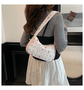 Quilted white tote bag with bear and strawberry prints worn by a model in casual style