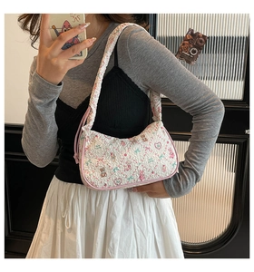 Lifestyle shot of floral quilted hobo bag with pink bow and cartoon bear patterns