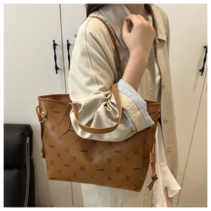 Détail d'un sac cabas marron avec motif de lapin et lettres de marque sur le cuir
