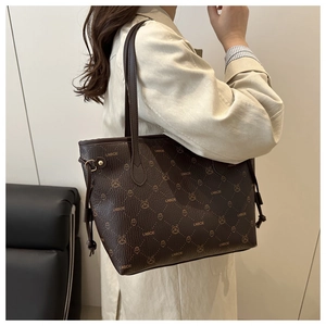 Détail d'un sac cabas marron à motif lapin porté sur un manteau beige