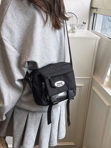 Japanese style black nylon messenger bag with adjustable strap and fashion utility buckle