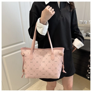 Détail du sac cabas rose en similicuir avec motifs d'ours et pompons sur le côté