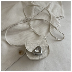 Détail du mini sac selle en cuir grainé blanc avec boucle coeur en métal argenté